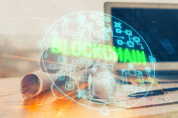 Double exposure of blockchain and crypto economy theme hologram and table with computer background....