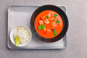 Fresh tomato soup with mushrooms and chicken meat in a black bowl. Tasty dinner.