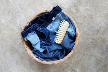 Jeans in laundry basket on cement floor background.