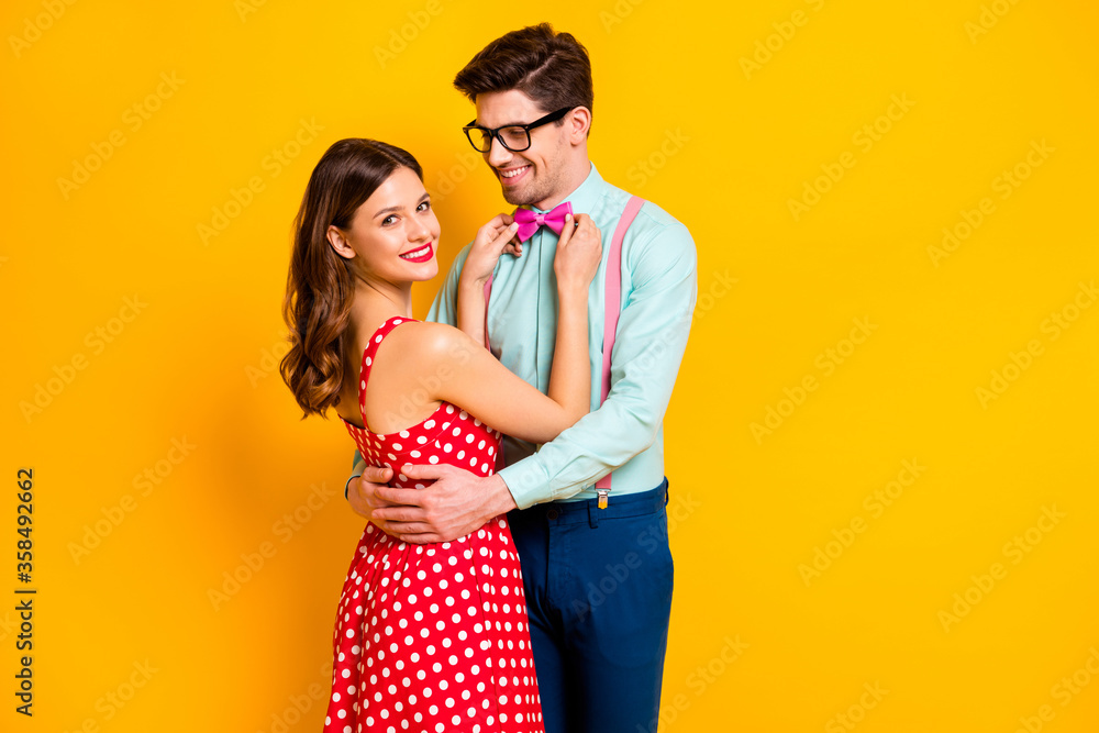 Sticker Portrait of positive couple girl fix her boyfriend bow-tie prepare for prom party event wear red dotted dress suspenders shirt pants trousers isolated over bright shine color background