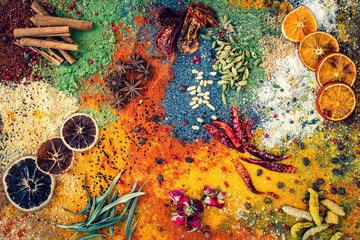 Many multi colored spices and dried fruits on the table