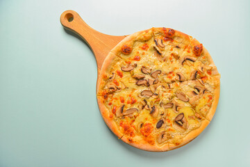 Mushroom pizza vegetarian served on a wooden board over pastel blue mint background. Italian cuisine. Copy space.
