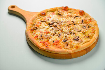 Mushroom pizza vegetarian served on a wooden board over pastel blue mint background. Italian cuisine. Copy space.