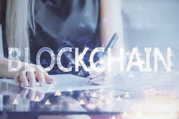 Cryptocurrency hologram over woman's hands writing background. Concept of blockchain. Double...