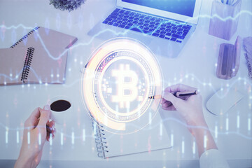 Cryptocurrency hologram over woman's hands writing background. Concept of blockchain. Multi exposure