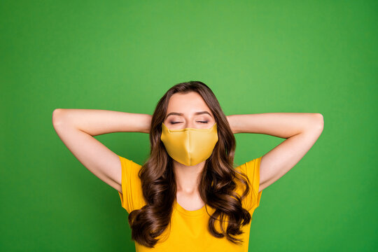 Close-up portrait of her she nice healthy dreamy wavy-haired girl wearing safety reusable cotton textile mask environment care rest isolated bright vivid shine vibrant green color background