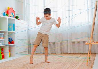 Fototapeta na wymiar boy brother, siblings, friendschild climbs through a rope web, a game obstacle quest indoors.