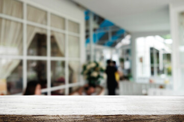 Empty wooden table space platform and blurred restaurant or coffee shop background for product display montage.