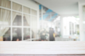 Empty wooden table space platform and blurred restaurant or coffee shop background for product display montage.