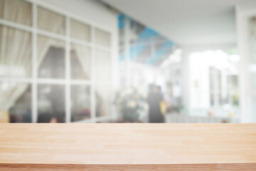 Empty wooden table space platform and blurred restaurant or coffee shop background for product display montage.