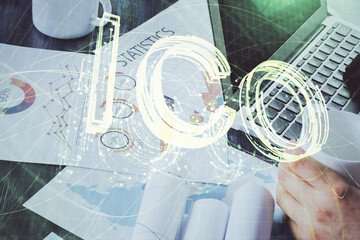 Crypto currency theme hologram with businessman working on computer on background. Concept of blockchain. Double exposure.