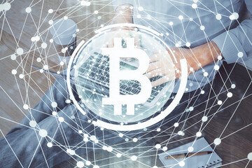 Crypto currency theme hologram with businessman working on computer on background. Concept of blockchain. Double exposure.