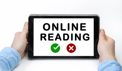 Male hands holding tablet pc with text ONLINE READING on white background