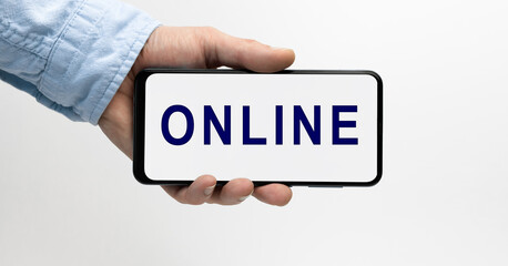 Man holding a smartphone horizontally with text ONLINE