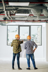 Horizontal medium shot of young Middle Eastern man working as architect holding tablet PC looking away, copy space