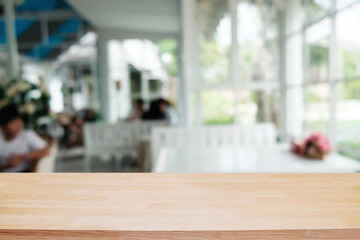 Empty wooden table space platform and blurred restaurant or coffee shop background for product display montage.