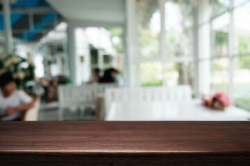 Empty wooden table space platform and blurred restaurant or coffee shop background for product display montage.