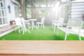 Naklejka premium Empty wooden table space platform and blurred restaurant or coffee shop background for product display montage.