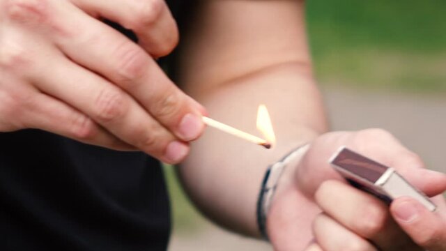 a man lights a match in the street