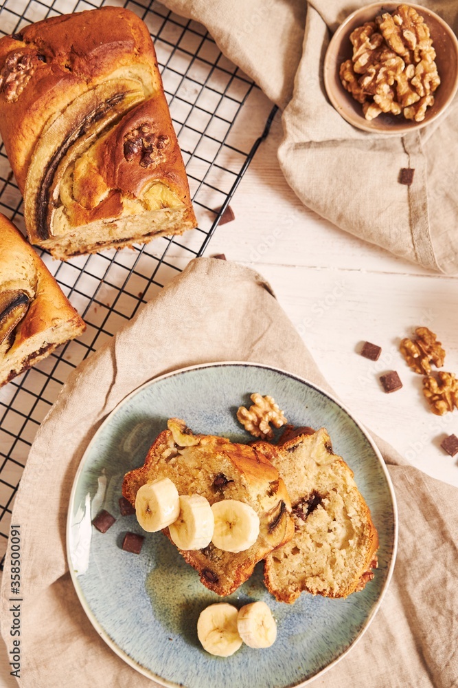 Poster vertical shot of slices of delicious banana bread with chocolate chunks and walnut on a table