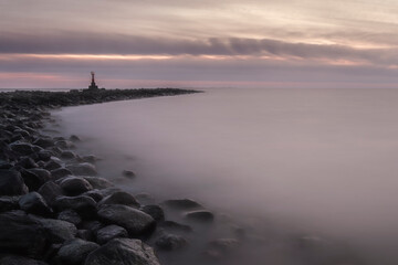 mystical foggy sea and rocky shore in the evening