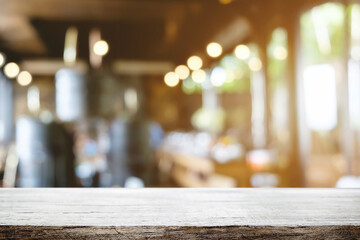 Empty wooden table space platform and blurred restaurant or coffee shop background for product display montage.