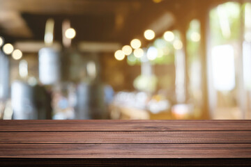 Fototapeta na wymiar Empty wooden table space platform and blurred restaurant or coffee shop background for product display montage.
