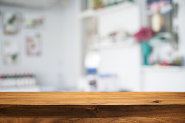 Empty wooden desk space platform over blurred restaurant or coffee shop background for product display montage.
