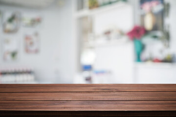 Empty wooden desk space platform over blurred restaurant or coffee shop background for product display montage.
