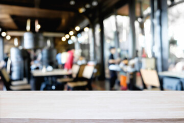Empty wooden desk space platform over blurred restaurant or coffee shop background for product display montage.