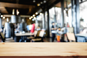 Empty wooden desk space platform over blurred restaurant or coffee shop background for product display montage.