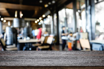 Empty wooden desk space platform over blurred restaurant or coffee shop background for product display montage.