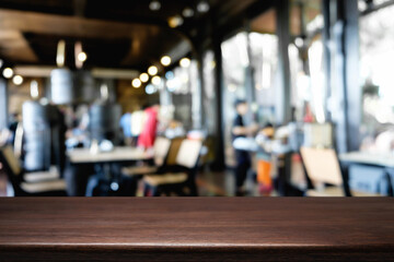 Empty wooden desk space platform over blurred restaurant or coffee shop background for product display montage.