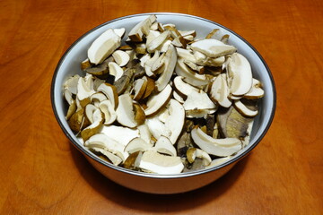 Sliced mushrooms in a bowl on the table ready for drying, summer boletus