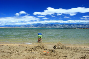 Fototapeta na wymiar Kid's playing in sand on the beach