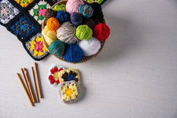Yarn balls,crochet needles,granny squares on white background.