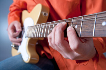 Fingers of a guitar player playing electric guitar.