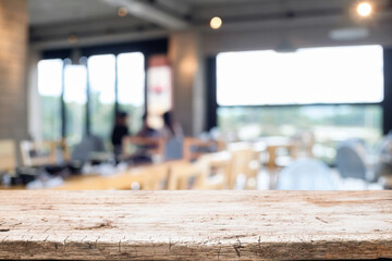 Empty wooden table space platform and blurred restaurant or coffee shop background for product display montage.