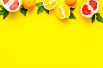 Citrus fruits on yellow background top view