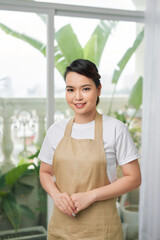 Beautiful happy young woman wearing kitchen apron