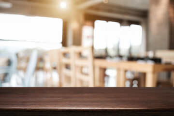 Obraz premium Empty wooden desk space platform with blur restaurant or coffee shop background for product display montage.