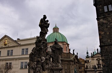 The statue of saints on the Charles Bridge under the tower in Prague (Czech Republic, Europe)