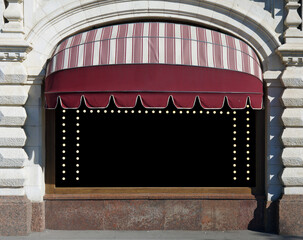 The restaurant window is decorated with a sun canopy and electric lamps