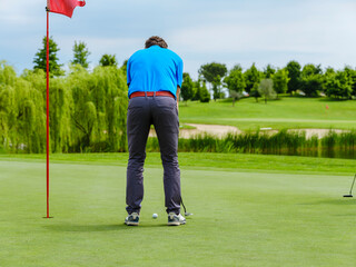 The golfer hits the ball with a putt