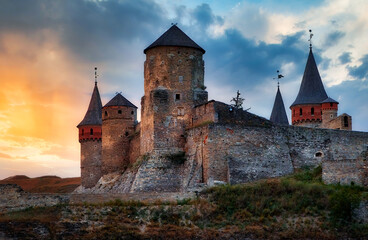 Obraz premium Kamianets Podilskyi old medieval fortress Ukraine. Famous fortified historic building tower exterior panorama. Sunset sky vivid colors