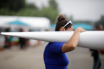 Details with the hand of a female professional rower carrying a kayak. - obrazy, fototapety, plakaty