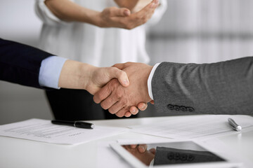 Fototapeta premium Business people shaking hands finishing contract signing, close-up. Business communication concept. Handshake and marketing