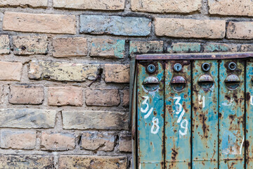 Old Soviet-style mailboxes. Old metal and numbered mailboxes on brick wall.