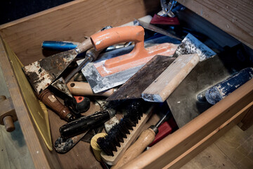 Workshop drawer with tools for plastering masonry and wallpaper.