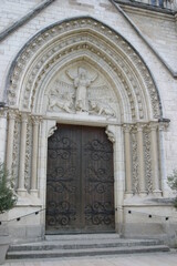 Fototapeta na wymiar Decorated door of a French church welcoming visitors and believers